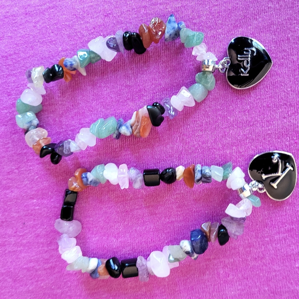 2  costume jewelry bracelets with "Kelly" hanging on a black heart shaped charm